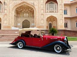 Vintage sepia-toned image of a luxury coupe with cantilevered fenders and art deco motifs